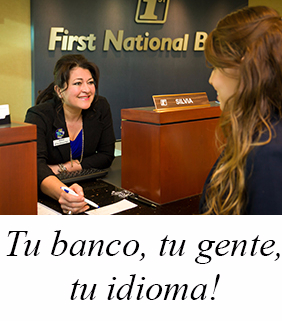 A banker behind the counter greets a customer.